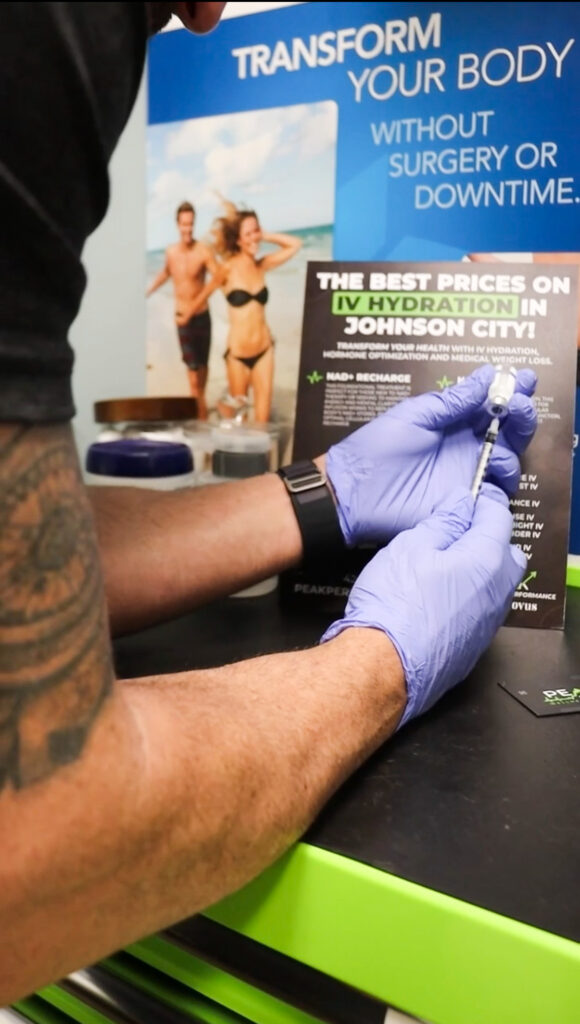 Clinician at Peak Performance Wellness and Aesthetics preparing a peptide injection in a syringe at the Johnson City, TN clinic